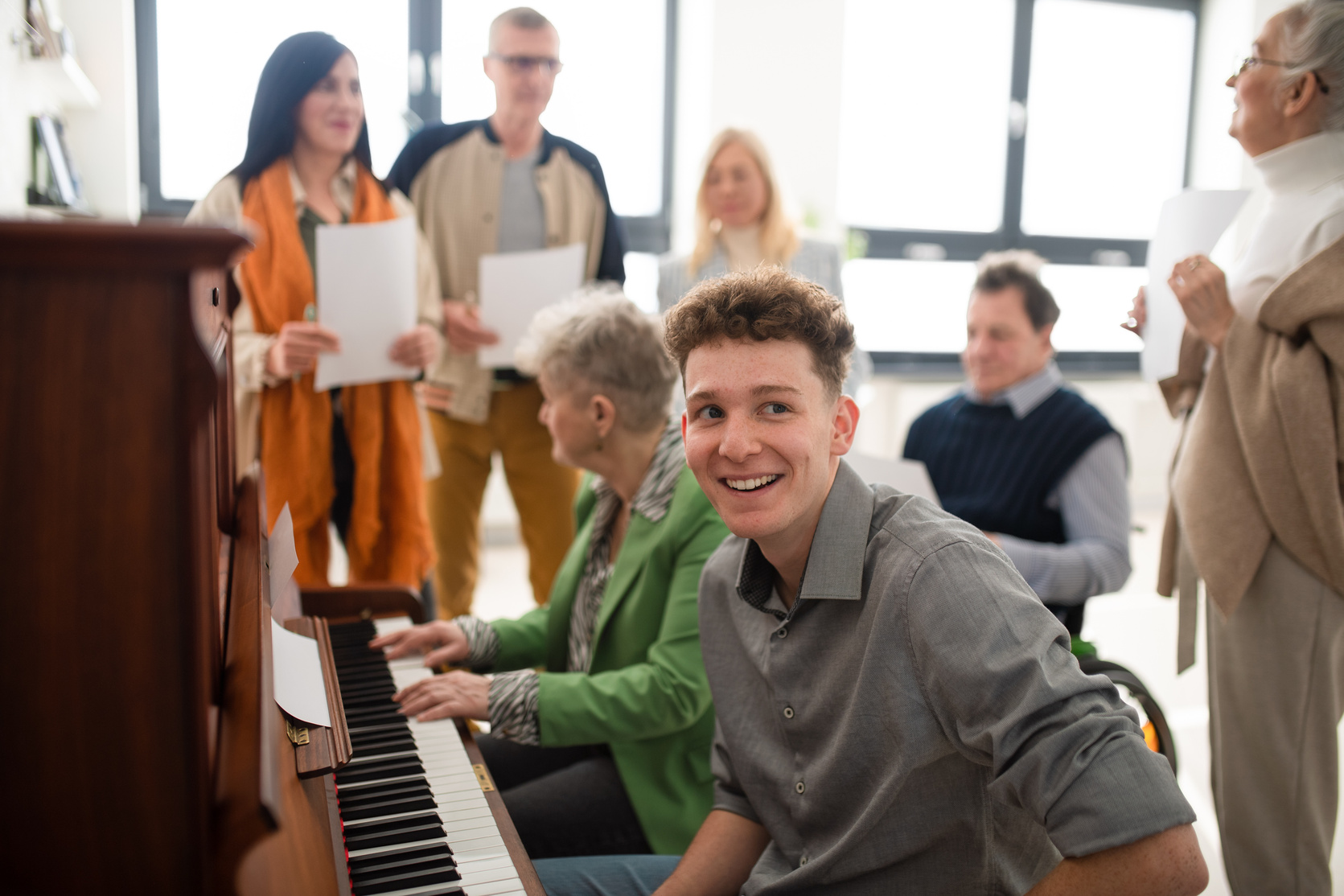 Group of Seniors with Young Teacher Singing Together at Choir Rehearsal.